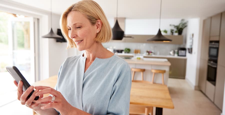 Resident using a smartphone in a stylish home